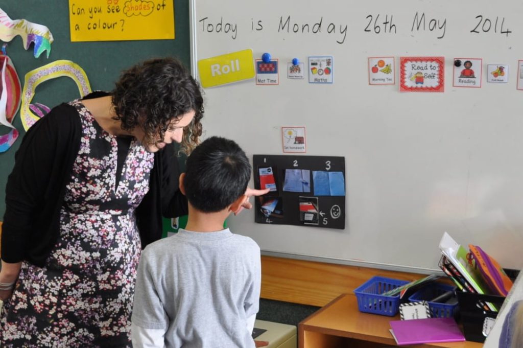 Teacher shows visual schedule to child